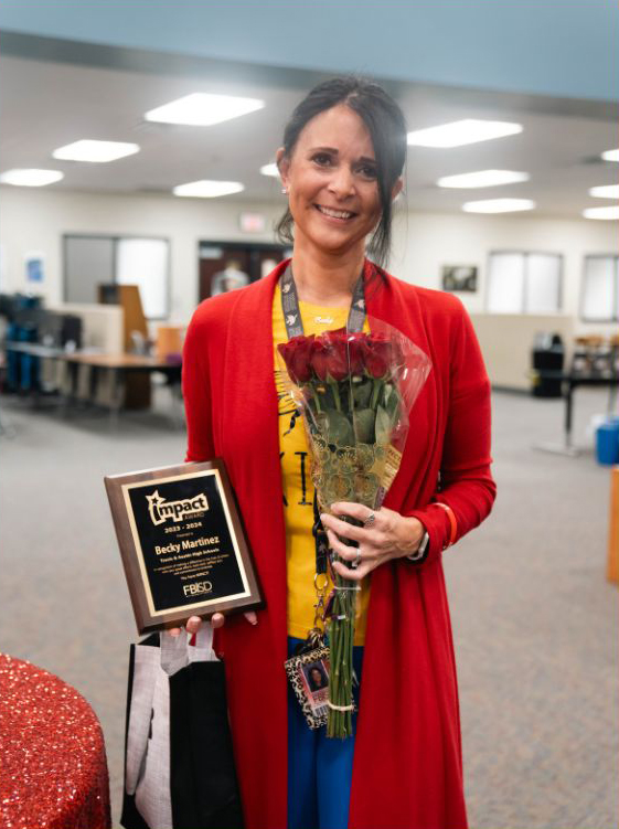 Becky Martinez holding her Impact Award plaque